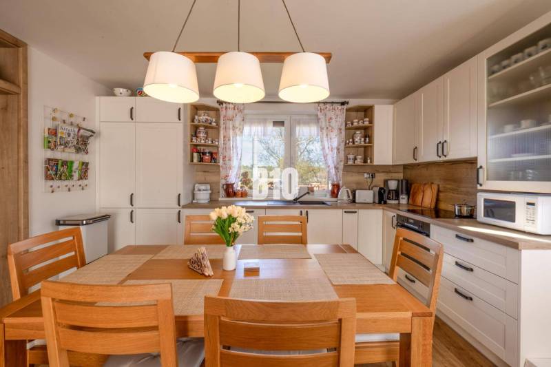 Küche in einem Einfamilienhaus mit Holzdekor und Esstisch.