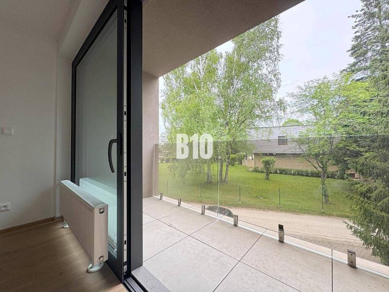 Balkon einer 2-Zimmer-Wohnung mit Blick ins Grüne und vergläntem Geländer.