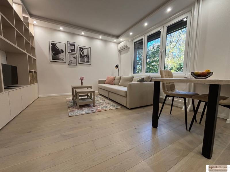 Wohnzimmer in einer 2-Zimmer-Wohnung, großes Sofa, Tisch, Boden mit Holzdekor.