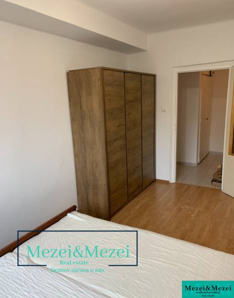 Ein Kleiderschrank mit Holzdekor in einer 2-Zimmer-Wohnung. Weiße Wand und Boden mit Holzdekor.