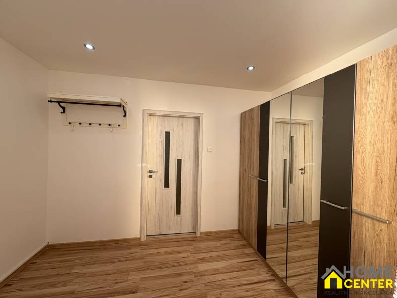 Ein Zimmer in einer 3-Zimmer-Wohnung mit einem Boden in Holzoptik und einem Spiegelschrank.