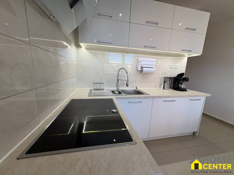 Elegante Küche in einer 3-Zimmer-Wohnung mit weißen Schränken und Induktionskochfeld.