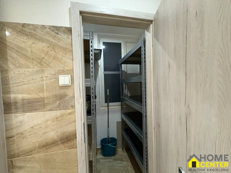 Ein kleiner Abstellraum in einer 3-Zimmer-Wohnung mit Regalen und einem Eimer.