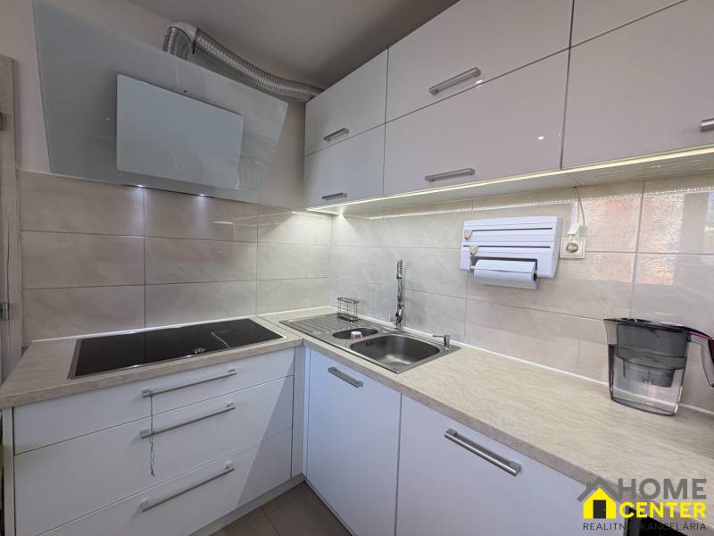 Küche mit eingebautem Kochfeld und Spüle in einer 3-Zimmer-Wohnung.