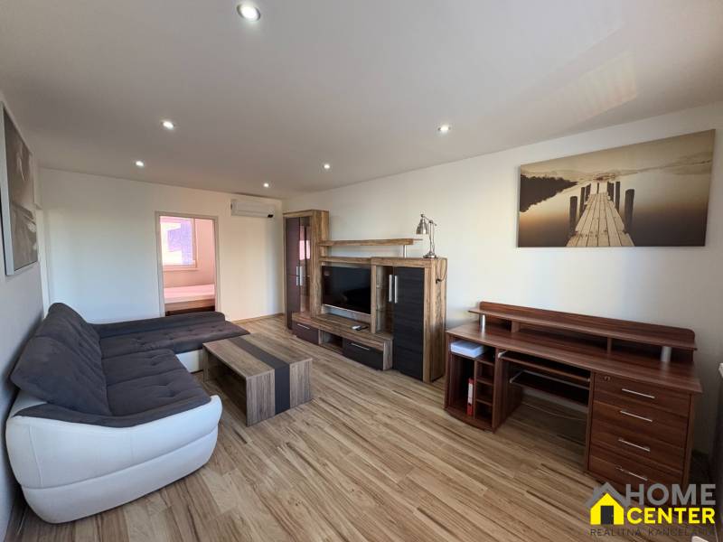 Wohnzimmer in einer 3-Zimmer-Wohnung mit Holzboden und bequemer Couch.