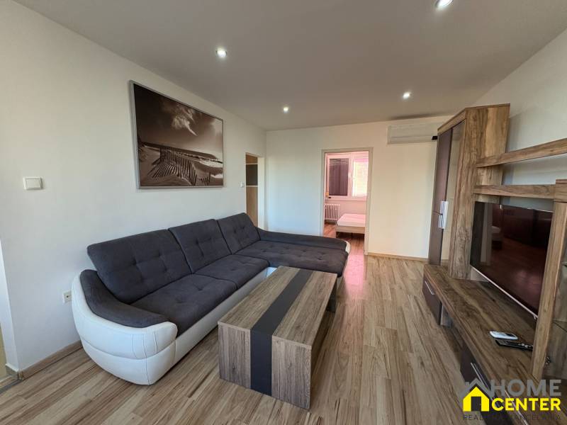 Wohnzimmer in einer 3-Zimmer-Wohnung mit Ecksofa und Holzboden.