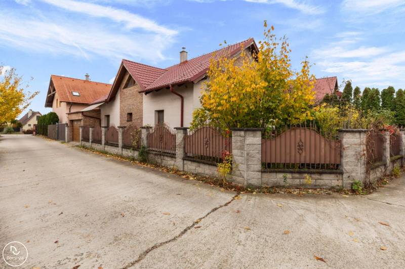 Ein Einfamilienhaus in der Straße Košariská in Rovinka mit einem Ziegeldach und einem Zaun.