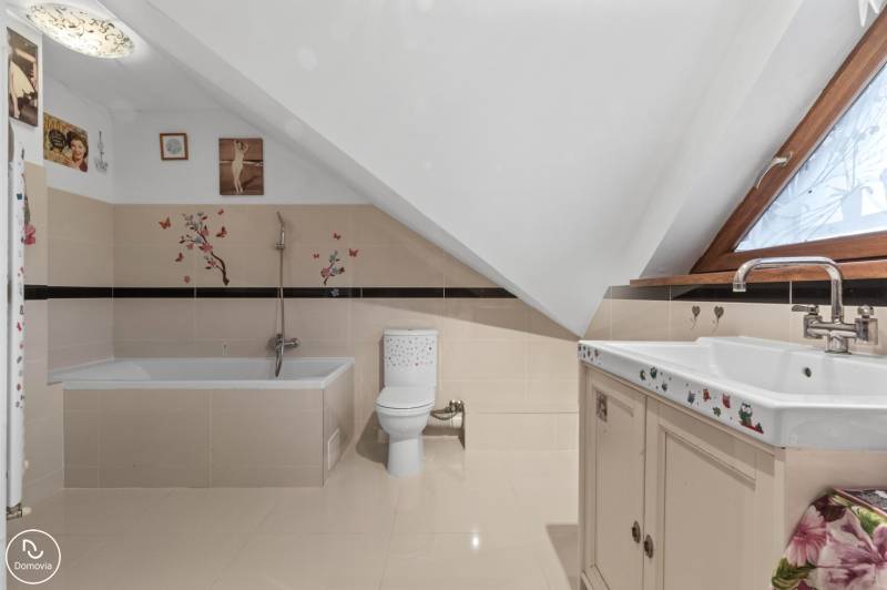 Badezimmer in einem Einfamilienhaus mit Badewanne, Toilette und dekorativen Aufklebern an den Wänden.