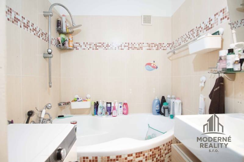 Badezimmer mit Badewanne in einer 3-Zimmer-Wohnung, Fliesen mit Mosaikdekor, Duscharmatur.