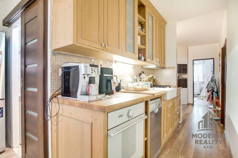 Küche in einer 3-Zimmer-Wohnung mit Holzdekor und Geräten.