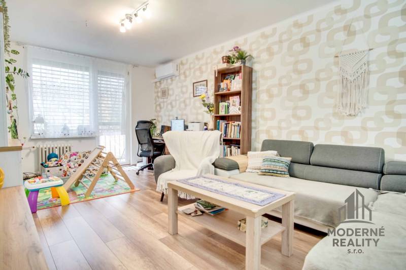 Wohnzimmer in einer 3-Zimmer-Wohnung mit Holzboden und Arbeitsecke.