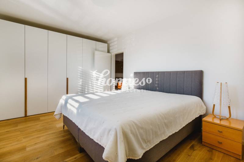 Schlafzimmer mit großem Bett, Kleiderschrank und Holzboden in einem Einfamilienhaus.