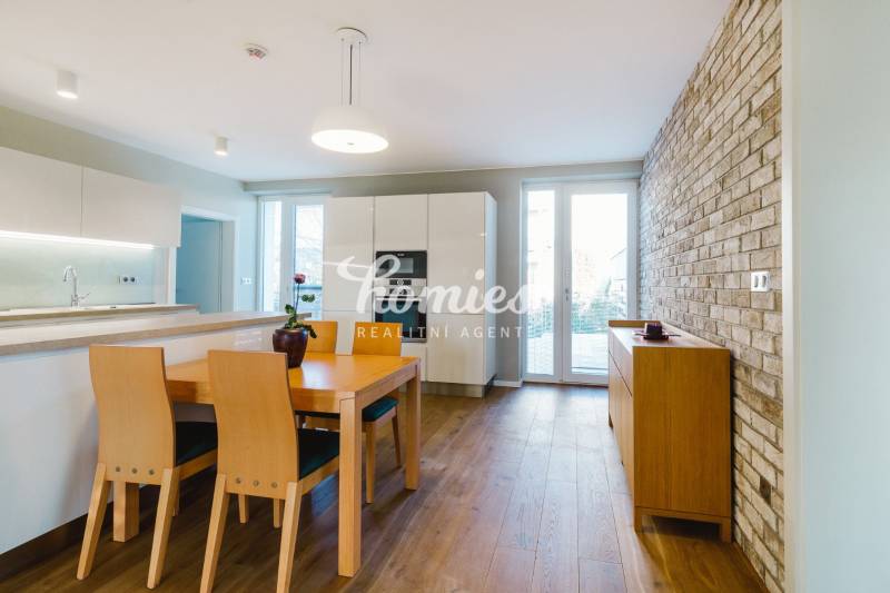 Küche in einem Einfamilienhaus mit Ziegelwand und Boden in Holzoptik.