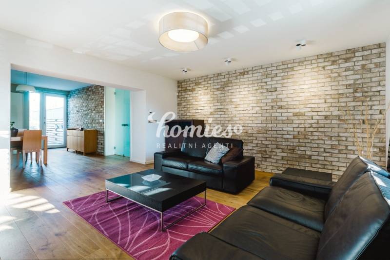 Wohnzimmer in einem Einfamilienhaus mit Ziegelwand und Boden in Holzoptik.