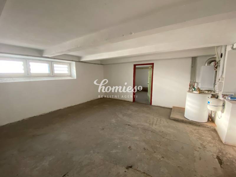 Ein leerer Raum in einem Einfamilienhaus mit Fenstern und einem Heizkessel.