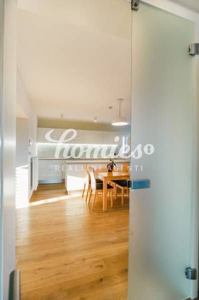 Eine Küche in einem Einfamilienhaus mit einem Boden in Holzoptik und einem Esstisch.