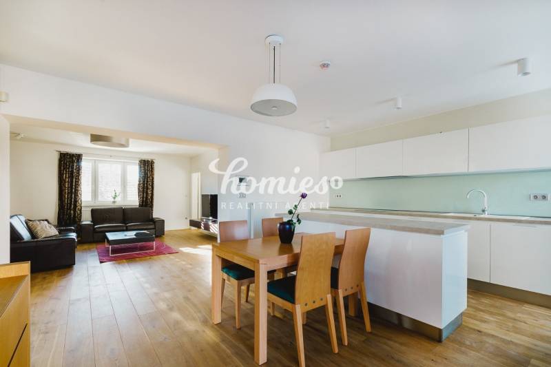 Küche und Wohnzimmer in einem Einfamilienhaus mit Holzboden und hellen Möbeln.