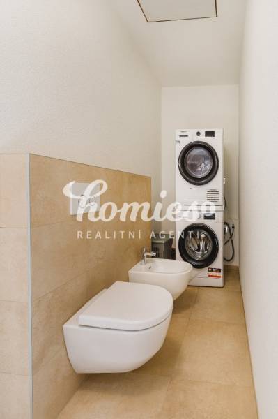 Badezimmer in einem Einfamilienhaus mit Waschmaschine, Trockner, Bidet und Toilette.