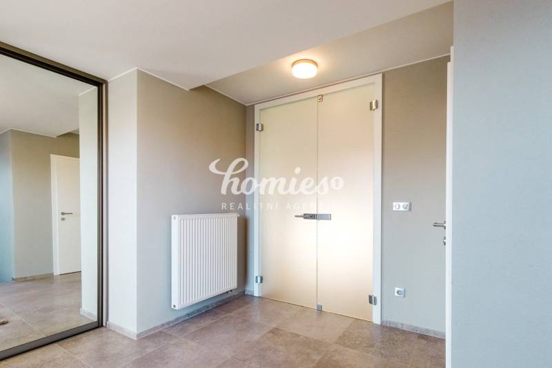 Eingangsbereich in einem Einfamilienhaus mit minimalistischem Design, Spiegel und hellen Wänden.