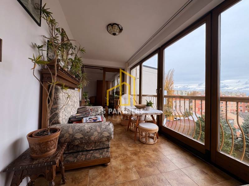 Ein geräumiger Balkon in einer Wohnung mit 5 oder mehr Zimmern mit großen Fenstern und einer gemütlichen Sitzecke.