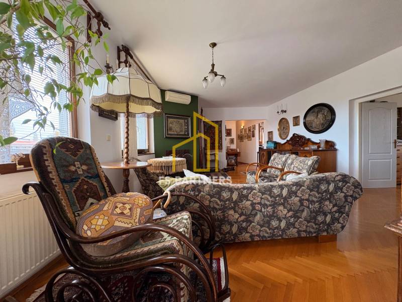 Wohnzimmer in einer Wohnung mit 5 oder mehr Zimmern mit Holzboden und Vintage-Möbeln.