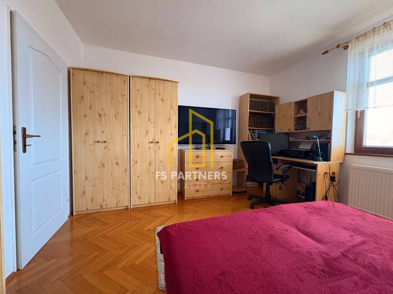 Ein Zimmer in einer 5-Zimmer-Wohnung oder größer mit einem Holzboden und einem Schreibtisch.