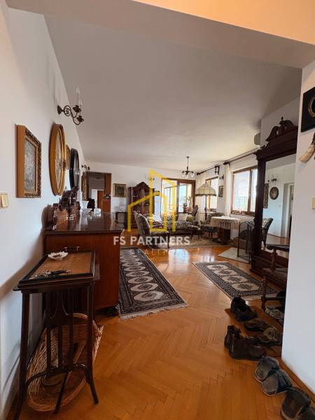 Eine Wohnung mit fünf oder mehr Zimmern, Holzboden, klassischem Möbel und Teppichen.