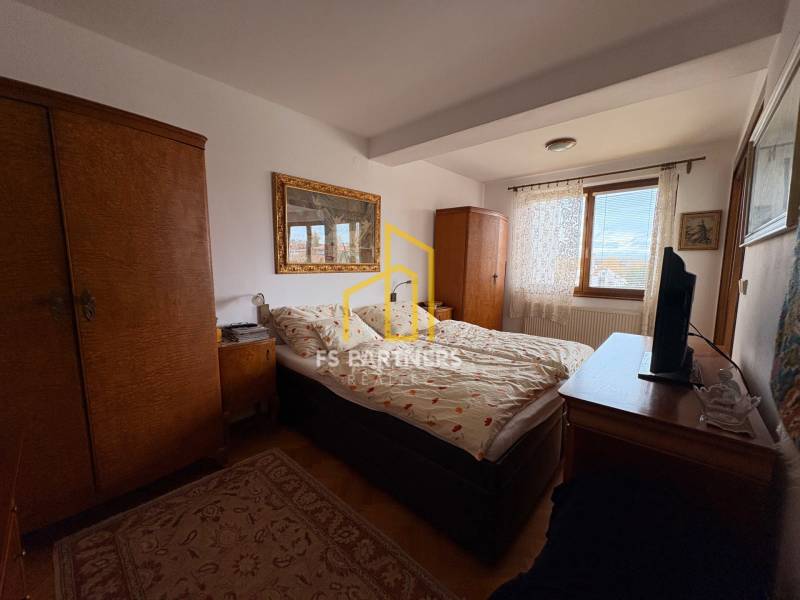 Schlafzimmer in einer Wohnung mit 5 oder mehr Zimmern mit Teppichboden und Holzschränken.