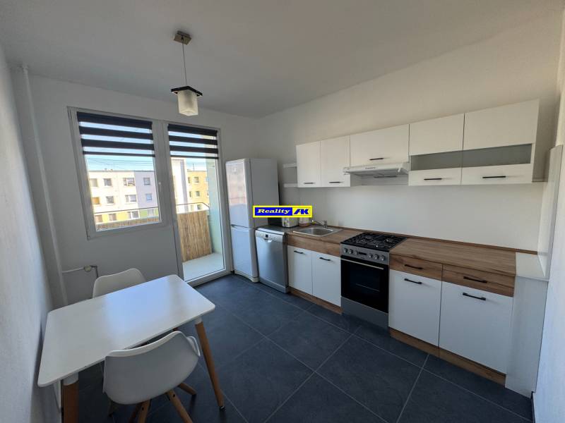 Küche in einer 3-Zimmer-Wohnung mit weißen Möbeln und Esstisch.