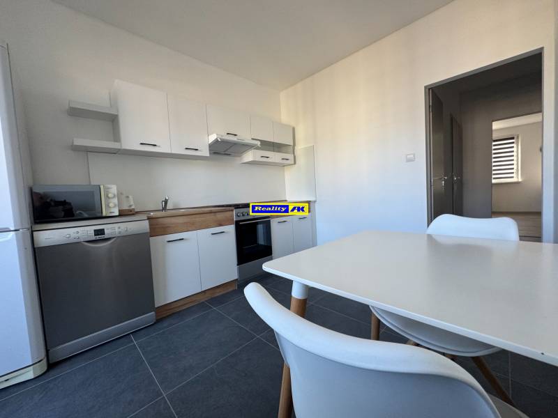 Die Küche einer 3-Zimmer-Wohnung mit weißen Möbeln und Geräten, Boden aus Keramikfliesen.