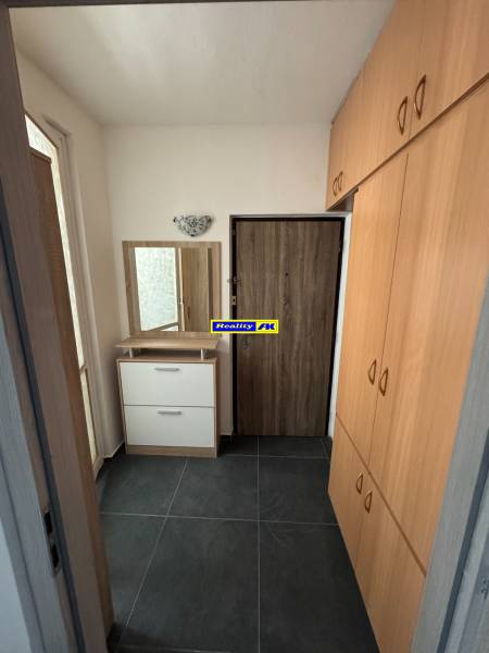 Flur mit dunklen Fliesen und Einbauschrank in einer 3-Zimmer-Wohnung.