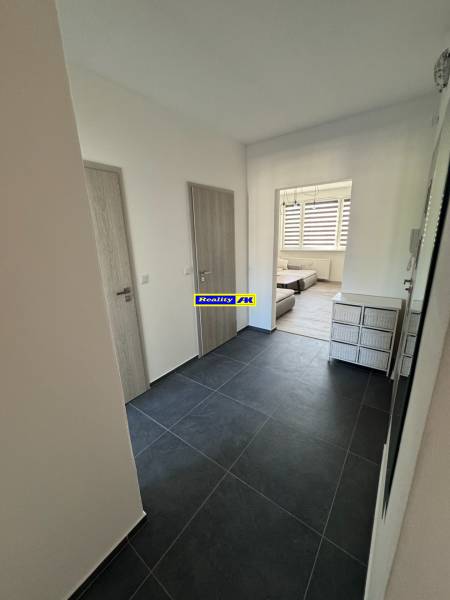 Eingangsflur in einer 3-Zimmer-Wohnung mit dunklen Fliesen und hellen Türen.