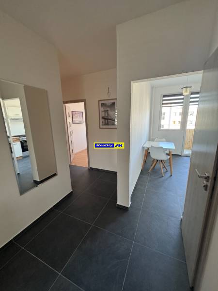 Flur mit dunklen Fliesen und Esszimmer in einer 3-Zimmer-Wohnung.