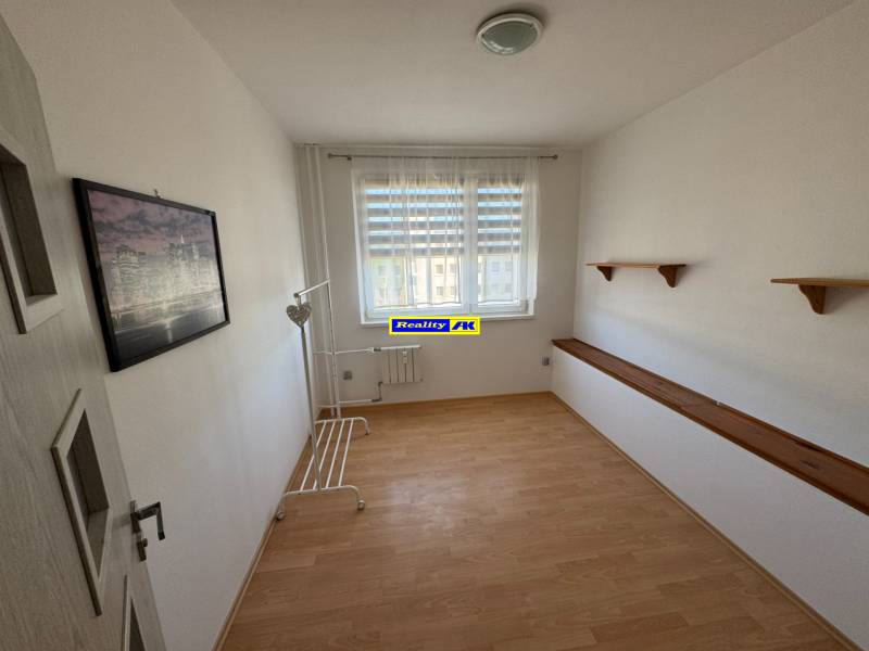 Helles Zimmer in einer 3-Zimmer-Wohnung mit Holzboden und Wandregalen.