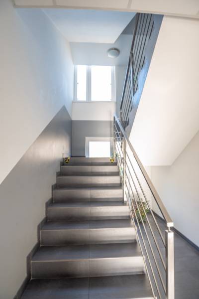 Eine Treppe mit einem Metallgeländer führt zu einem Fenster in den Büros.