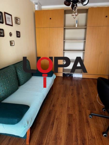 Ein Zimmer in einer 3-Zimmer-Wohnung mit einem Boden in Holzoptik und Einbauschränken.