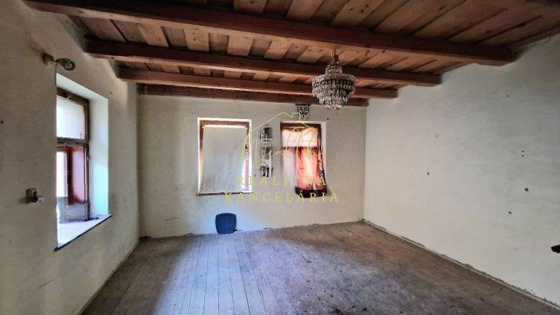 Ein Raum in einem Einfamilienhaus mit einer Holzdecke und einem Boden in Holzoptik.