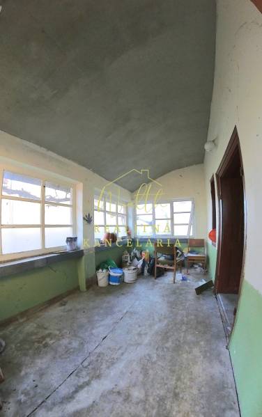 Innenraum eines Einfamilienhauses mit alten Fenstern und Betonboden.