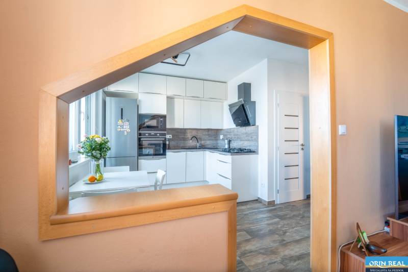 Küche in einer 3-Zimmer-Wohnung mit modernen Geräten und einem Boden in Holzoptik.