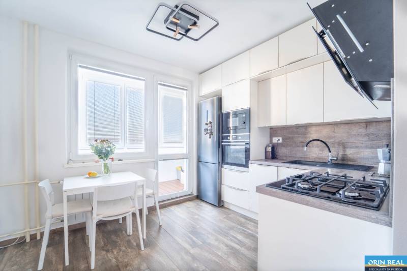 Küche in einer 3-Zimmer-Wohnung mit Holzboden und hellen Möbeln.