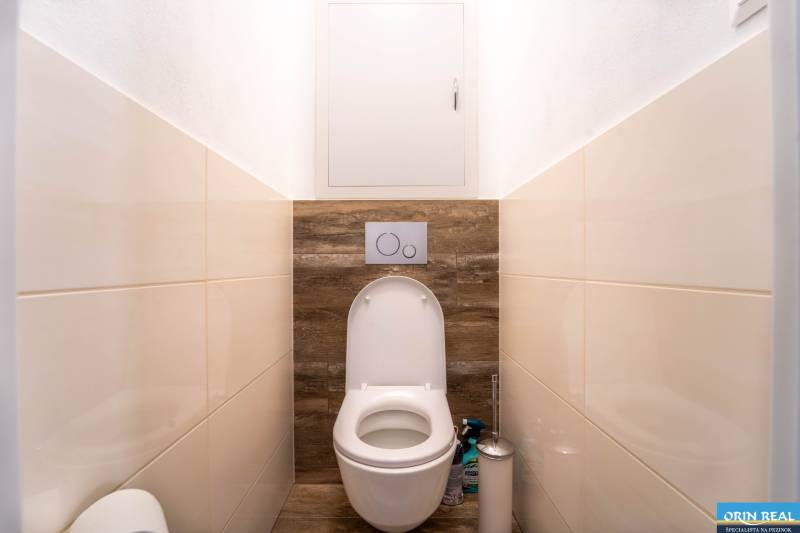 Badezimmer mit Toilette und Boden in Holzoptik in einer 3-Zimmer-Wohnung.