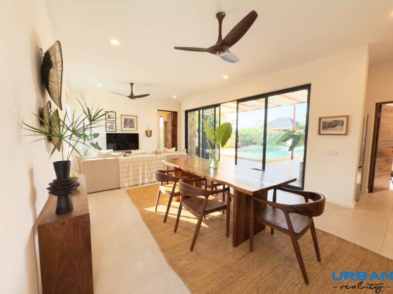 Innenraum mit Esstisch, Holzboden und großen Glastüren, Hausbau.