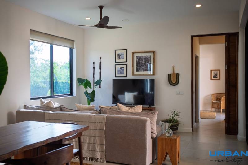 Ein Interieur mit einem Sofa, einem Fernseher und Holzmöbeln im Bau von Häusern.