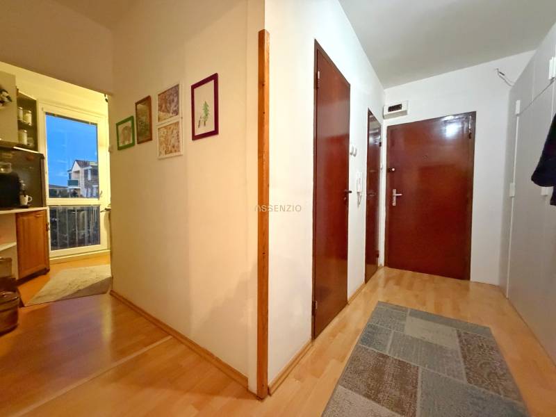 Flur einer 3-Zimmer-Wohnung mit Holzboden, Bilder an den Wänden.