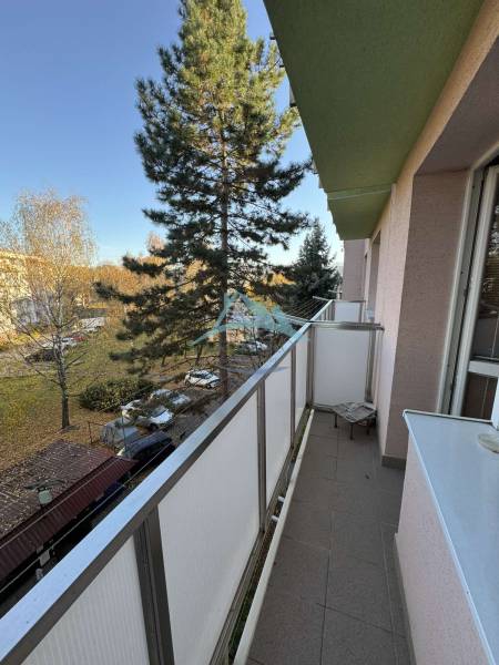 Der Balkon einer 3-Zimmer-Wohnung in der Vajanského-Straße in Šahy mit Blick auf das Grün.
