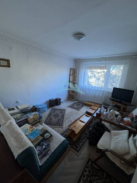 Wohnzimmer in einer 3-Zimmer-Wohnung mit Holzboden und Möbeln.