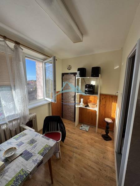 Esszimmer in einer 3-Zimmer-Wohnung mit Holzboden und offenem Fenster.