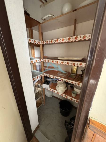 Speisekammer in einer 3-Zimmer-Wohnung mit eingebauten Regalen und gelagerten Küchenutensilien.