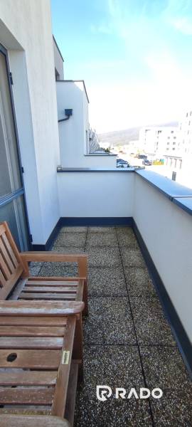 Balkon mit Bank in einer 2-Zimmer-Wohnung in der Predmerského-Straße, Trenčín, mit Blick auf die Stadt.