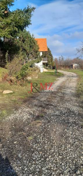 Freizeitgrundstücke Horné Jabloňovce in Jabloňovce mit einem Gehweg neben einem kleinen Haus und Bäumen.